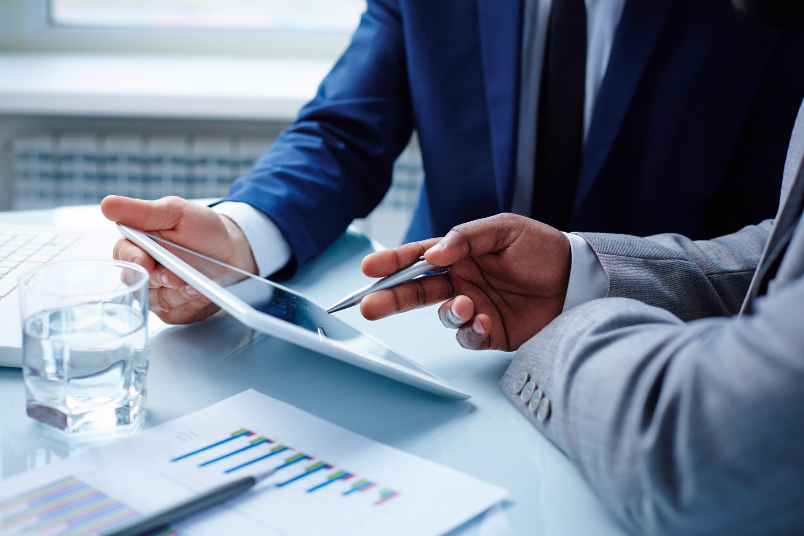 image-of-businessmen-discussing-data-in-touchpad-at-meeting-SBI-300726656-scaled.jpg